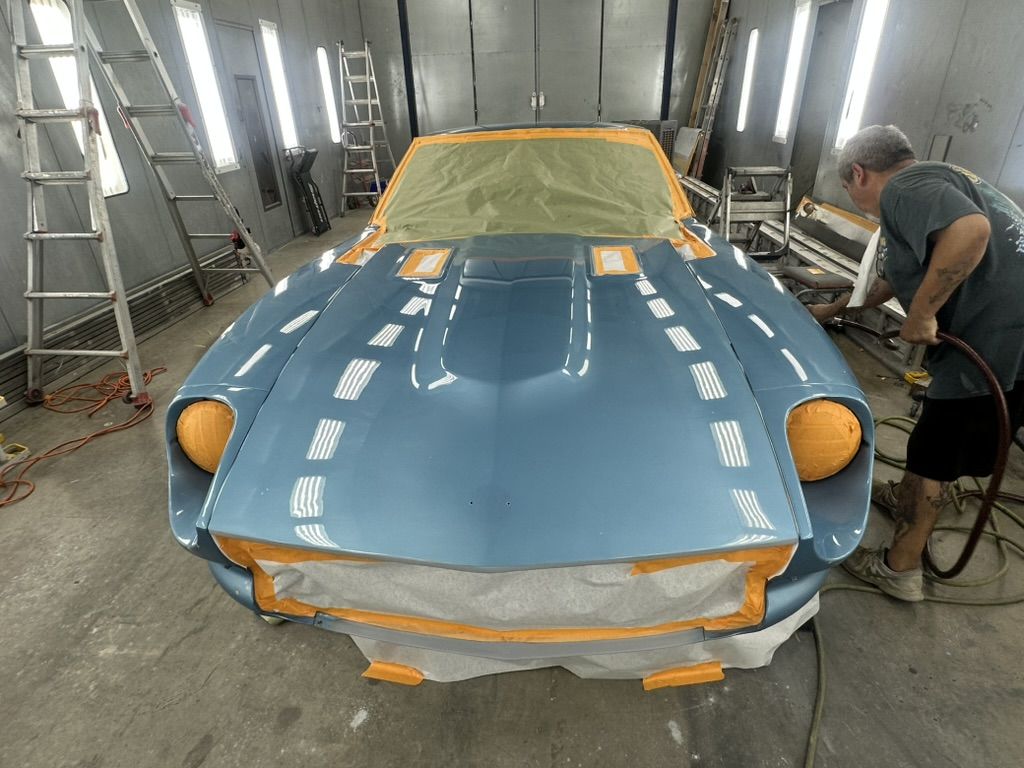 Freshly sprayed hood of the 1977 Datsun 280Z reflecting the booth lights