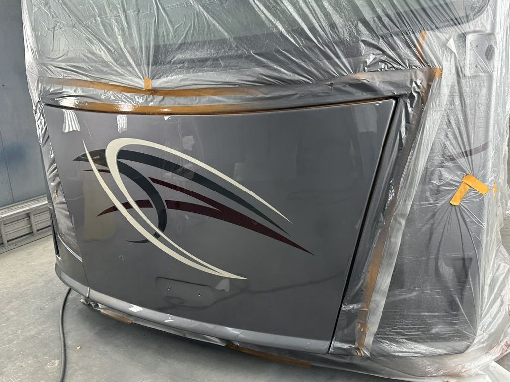 Motorhome front cap in the booth after the gloss clear coat, graphics restored