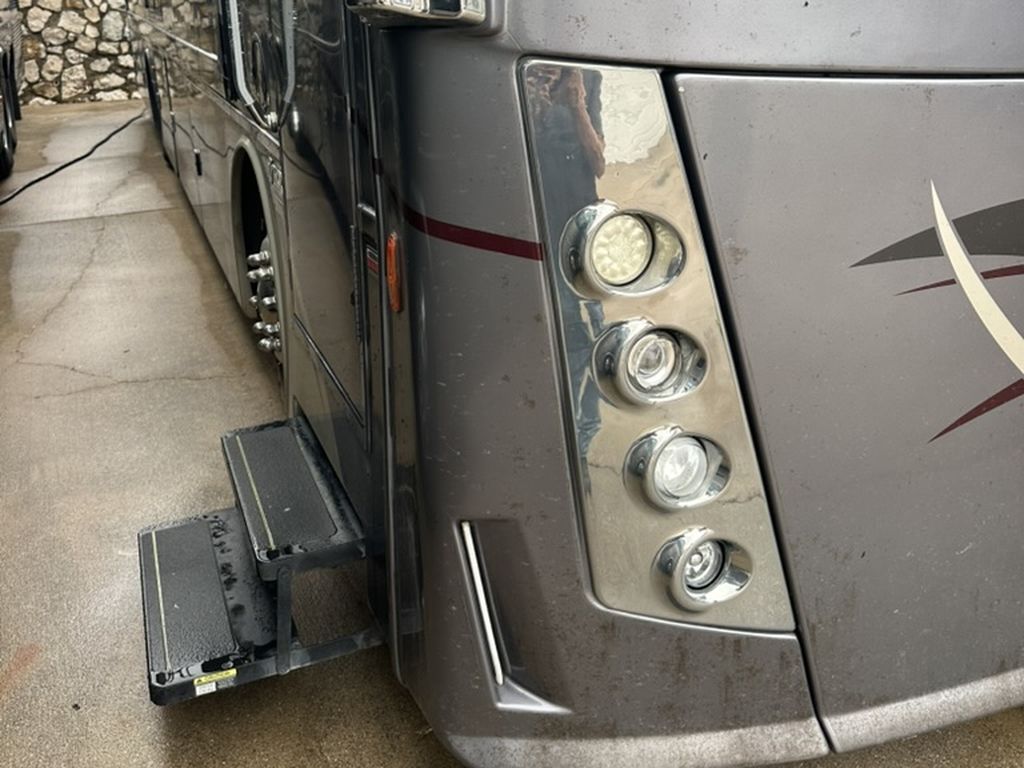 Motorhome front corner and headlight surround before service, dull and dirty under old film