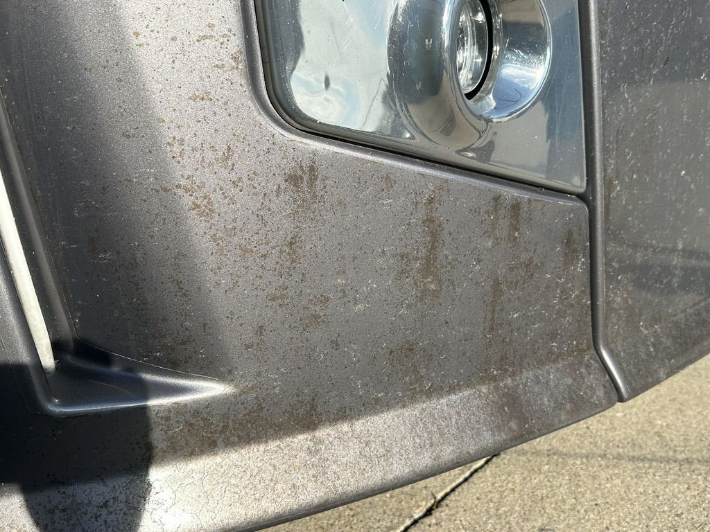 Stained and pitted lower front cap and bumper on a motorhome before refinishing