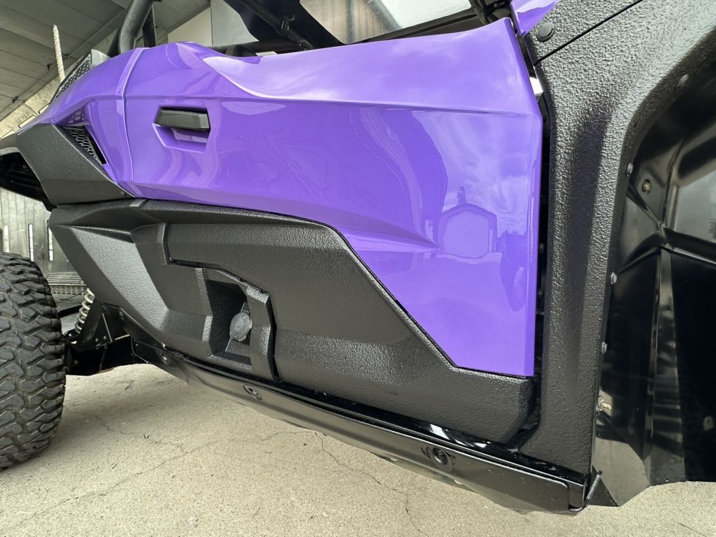 Close-up of a purple UTV door panel with mirror-gloss Paint Shield finish above a textured black rocker