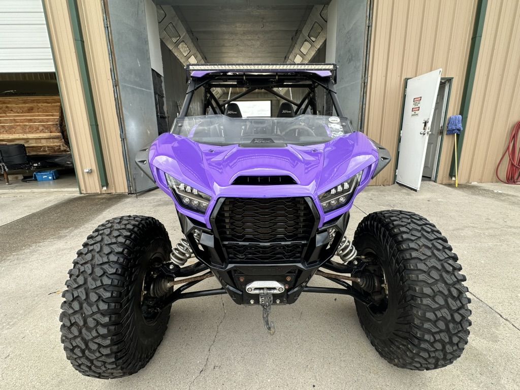 Front view of a purple Kawasaki Teryx KRX with AeroArmor Paint Shield in high-gloss purple