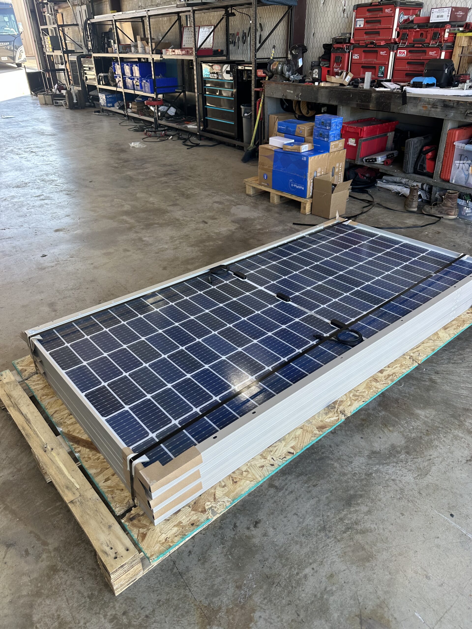 Solar panels stacked on pallet in Patriots RV Services shop ready for installation